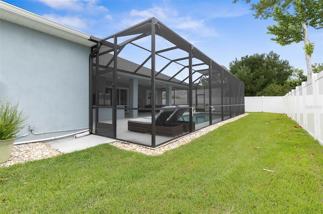 rear view of house with a yard, a lanai, a fenced in pool, and a patio