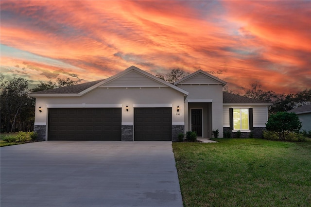 view of front of property with a garage and a yard