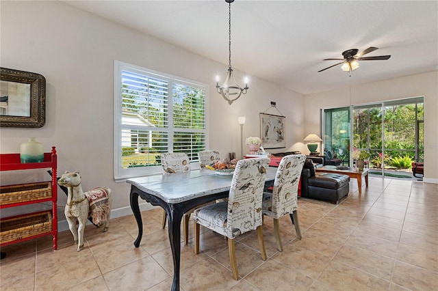 tiled dining space featuring ceiling fan with notable chandelier