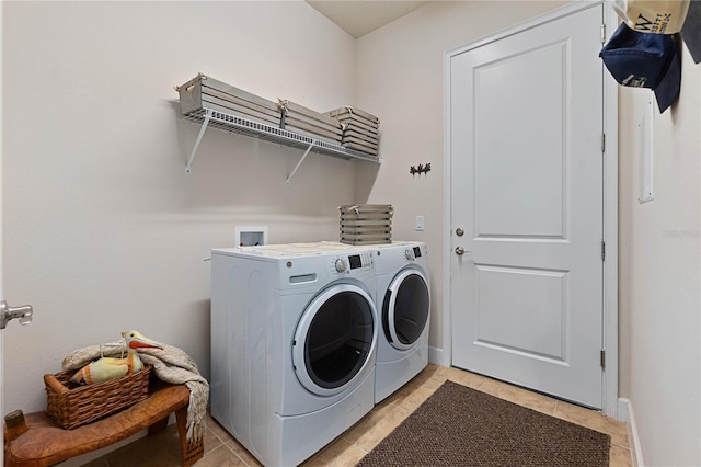 laundry area with light tile patterned floors and washing machine and dryer