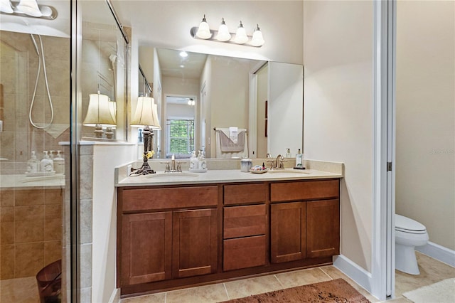 bathroom with vanity, toilet, tile patterned flooring, and a shower with door