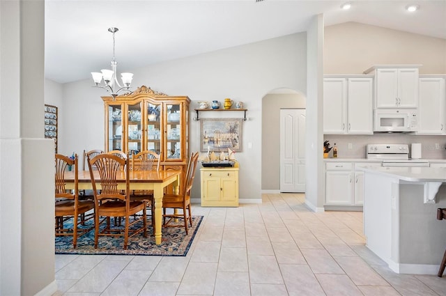 dining room with light tile patterned flooring, high vaulted ceiling, and a notable chandelier