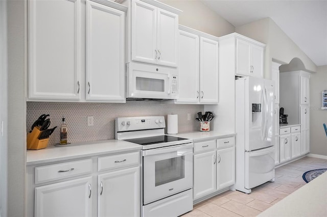 kitchen with white appliances, decorative backsplash, and white cabinets