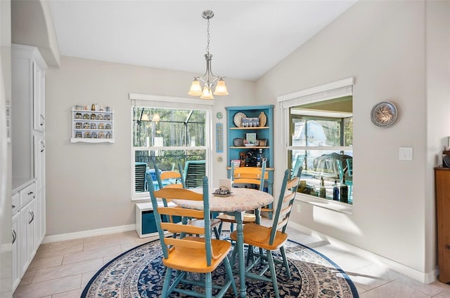 dining area featuring an inviting chandelier, plenty of natural light, vaulted ceiling, and light tile patterned floors