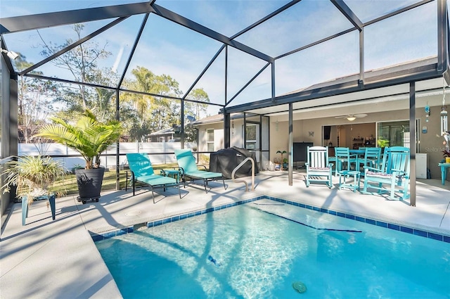 view of swimming pool with a patio, a lanai, and ceiling fan