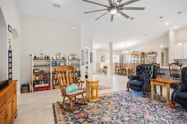 tiled living room with vaulted ceiling and ceiling fan with notable chandelier