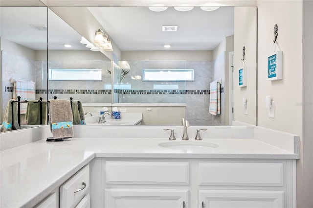 bathroom with vanity and a tile shower