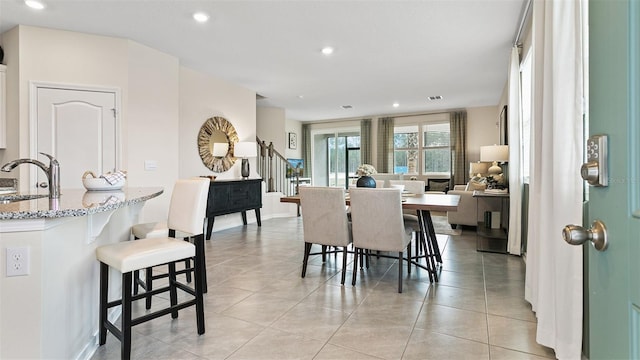 dining space featuring sink and light tile patterned floors