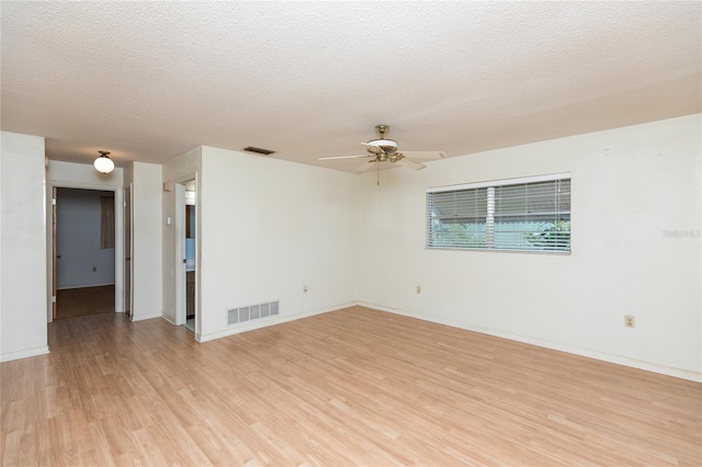 unfurnished room with ceiling fan, a textured ceiling, and light wood-type flooring