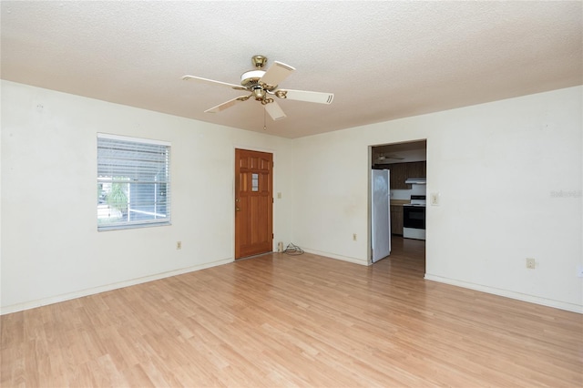empty room with a textured ceiling, ceiling fan, and light wood-type flooring