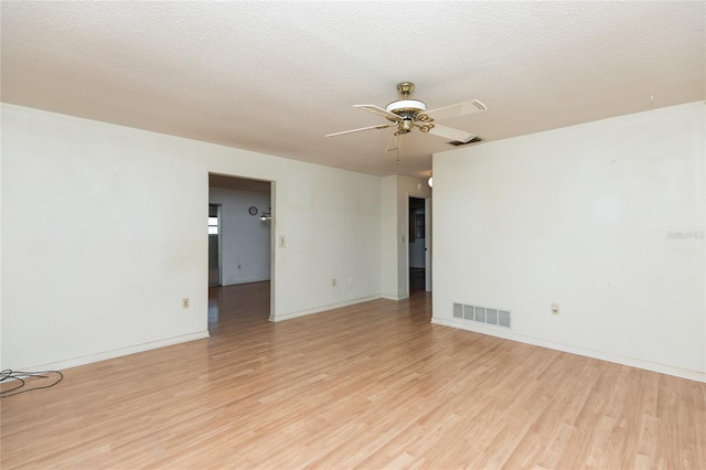 empty room with ceiling fan, a textured ceiling, and light wood-type flooring