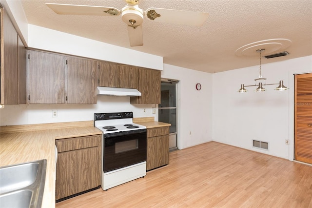 kitchen featuring pendant lighting, sink, range with electric cooktop, a textured ceiling, and light wood-type flooring