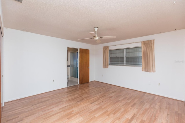 unfurnished room with ceiling fan, a textured ceiling, and light wood-type flooring