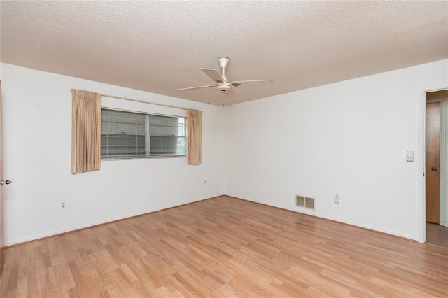 empty room with a textured ceiling, ceiling fan, and light wood-type flooring