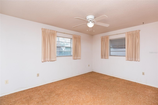 carpeted empty room featuring ceiling fan and a textured ceiling