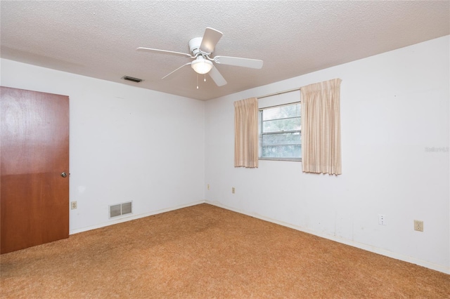 spare room featuring ceiling fan, carpet, and a textured ceiling