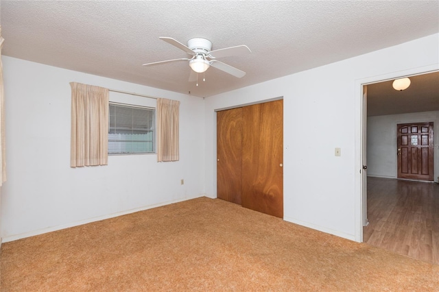 unfurnished bedroom featuring ceiling fan, carpet floors, a closet, and a textured ceiling