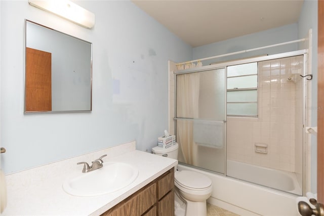 full bathroom with vanity, bath / shower combo with glass door, and toilet