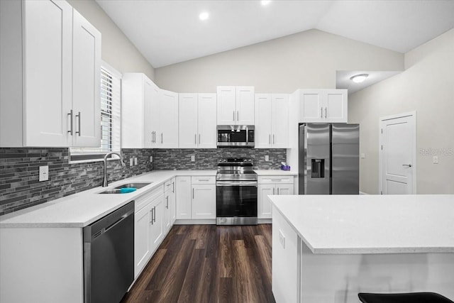 kitchen with white cabinetry, sink, vaulted ceiling, and stainless steel appliances