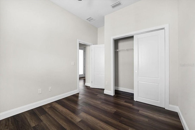 unfurnished bedroom featuring dark hardwood / wood-style flooring and a closet