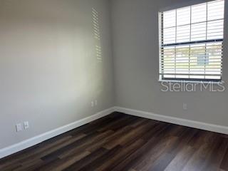 empty room with dark hardwood / wood-style flooring