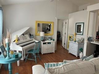 miscellaneous room with dark wood-type flooring, ceiling fan, and vaulted ceiling