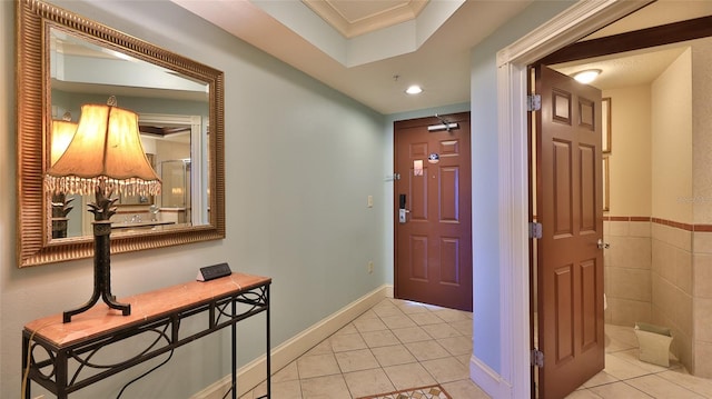 foyer entrance featuring light tile patterned flooring and baseboards