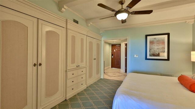 bedroom featuring a ceiling fan, visible vents, and beam ceiling