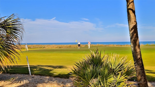 view of community featuring view of golf course, a lawn, and a water view