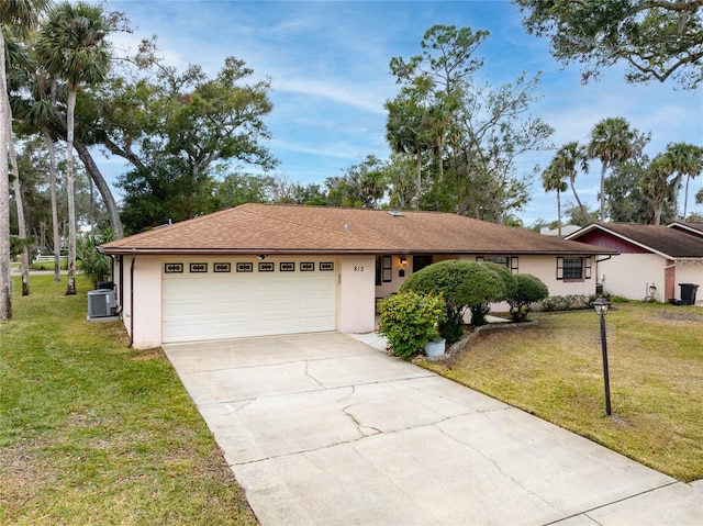 ranch-style house with central AC unit, a garage, and a front yard