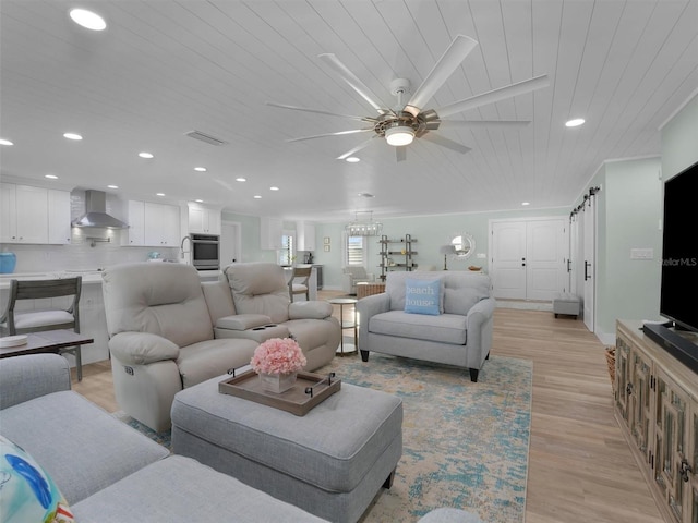 living room with a barn door, wooden ceiling, ceiling fan, and light hardwood / wood-style flooring