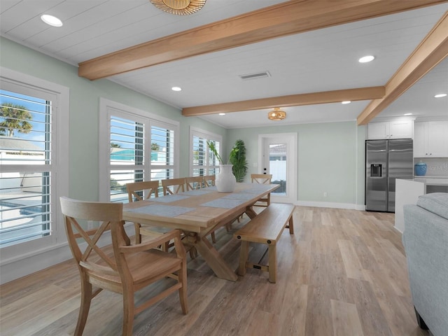 dining space featuring beamed ceiling and light hardwood / wood-style floors