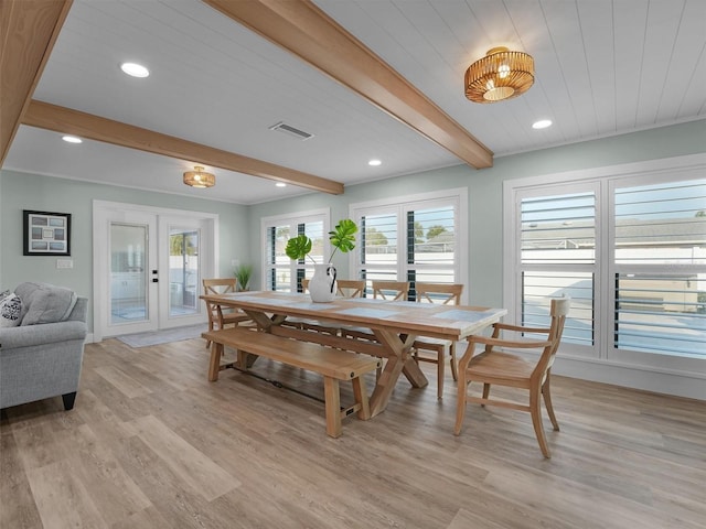 dining area with light hardwood / wood-style floors, beam ceiling, and french doors