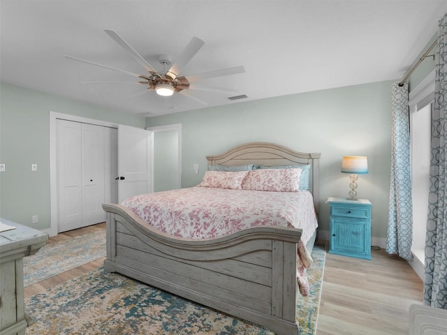 bedroom with light hardwood / wood-style flooring, a closet, and ceiling fan