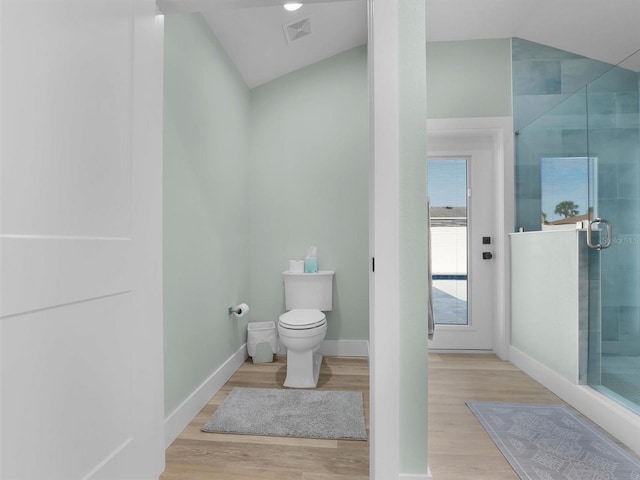 bathroom featuring lofted ceiling, toilet, an enclosed shower, and hardwood / wood-style floors