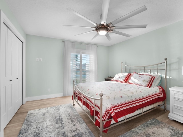 bedroom featuring hardwood / wood-style flooring, ceiling fan, a textured ceiling, and a closet