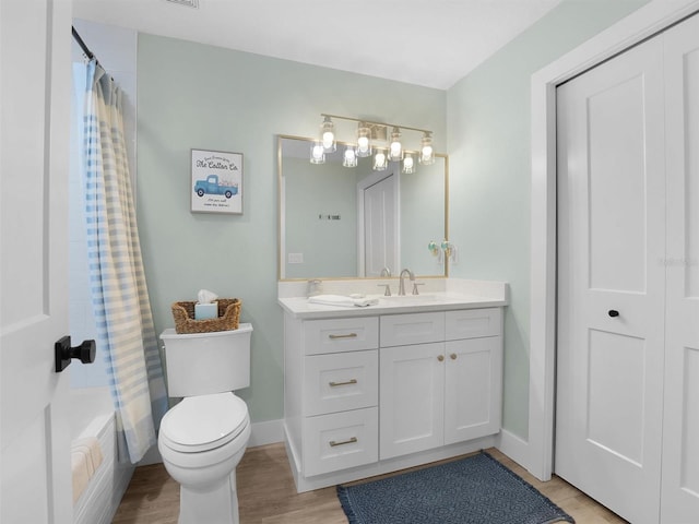 full bathroom with vanity, wood-type flooring, shower / bathtub combination with curtain, and toilet