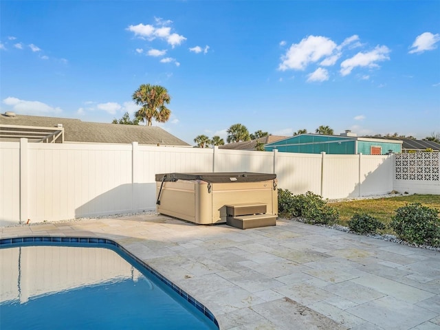 view of swimming pool featuring a hot tub and a patio