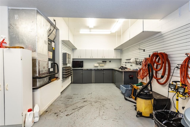 kitchen featuring gray cabinets, white cabinetry, and concrete floors