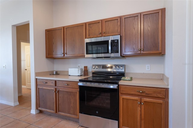 kitchen featuring stainless steel appliances and light tile patterned flooring