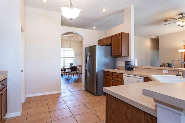 kitchen with light tile patterned floors, decorative light fixtures, sink, and white dishwasher