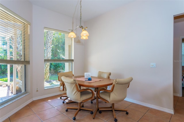 dining area featuring light tile patterned flooring and an inviting chandelier