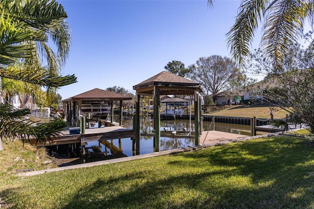 view of dock with a lawn and a water view