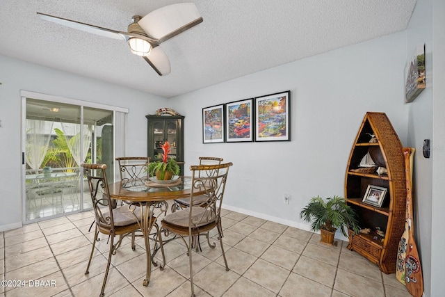 dining space with ceiling fan, light tile patterned floors, and a textured ceiling