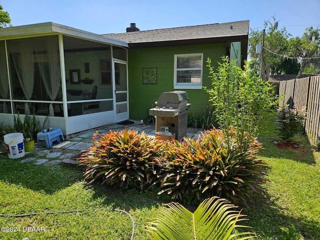 back of house with a yard and a sunroom