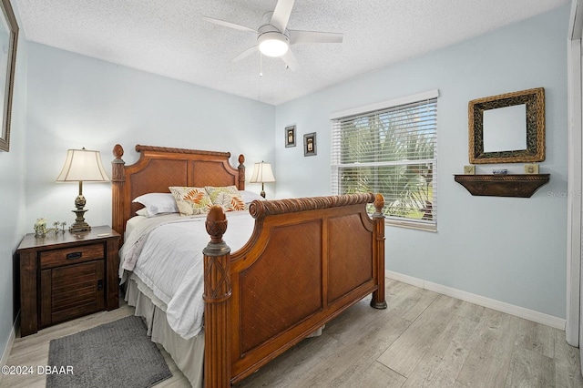 bedroom featuring ceiling fan, a textured ceiling, and light wood-type flooring