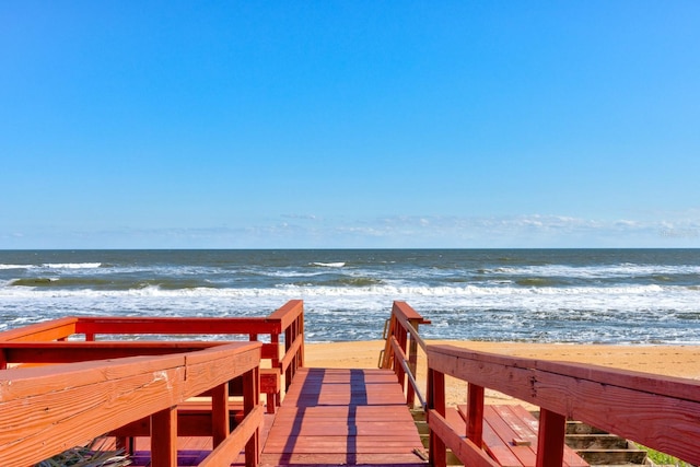 view of property's community featuring a water view and a beach view