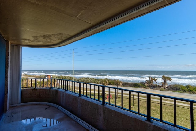 balcony with a water view and a beach view