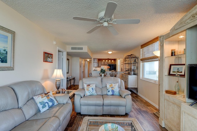 living room with ceiling fan, a textured ceiling, and dark hardwood / wood-style flooring