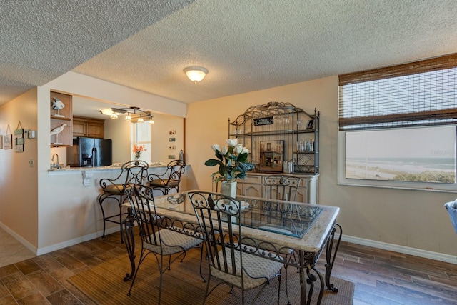 dining space featuring dark hardwood / wood-style flooring and a textured ceiling